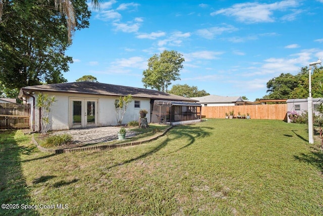 3664 Longbow Rd, Cocoa, FL 32926 - rear view of house featuring french doors, a sunroom, a fenced backyard, and stucco siding
