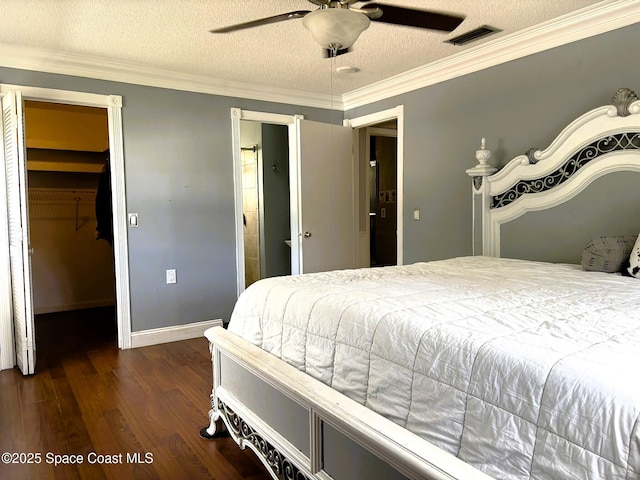 292 Pine Tree Dr, Indialantic, FL 32903 - bedroom with dark wood-type flooring, a walk in closet, crown molding, a textured ceiling, and a closet