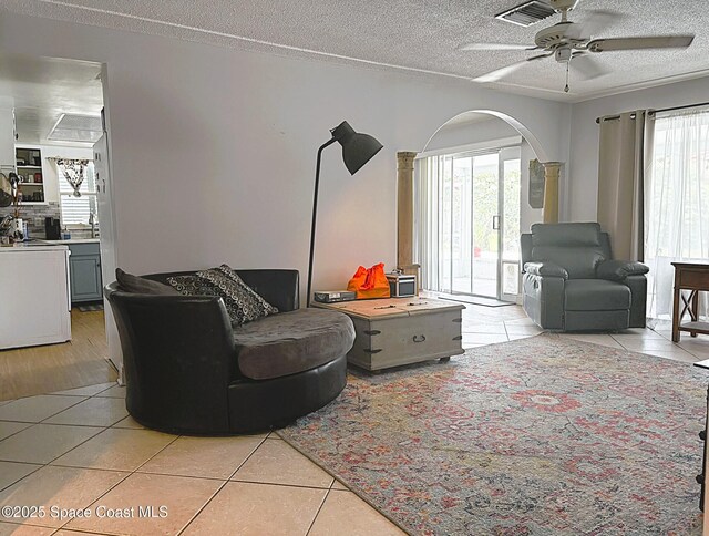 292 Pine Tree Dr, Indialantic, FL 32903 - living area featuring light tile patterned flooring, a textured ceiling, healthy amount of natural light, and ceiling fan