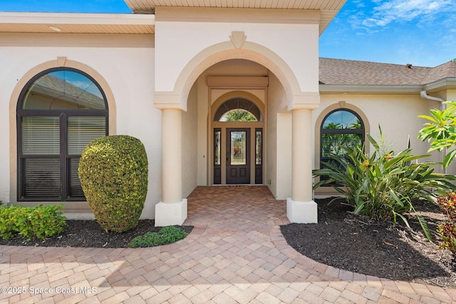 7987 Bradwick Way, Melbourne, FL 32940 - doorway to property with stucco siding and a shingled roof