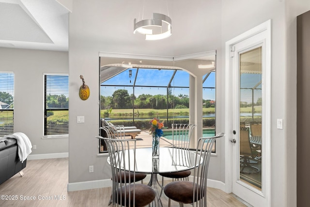 7987 Bradwick Way, Melbourne, FL 32940 - dining area featuring light wood-type flooring, a sunroom, and a water view