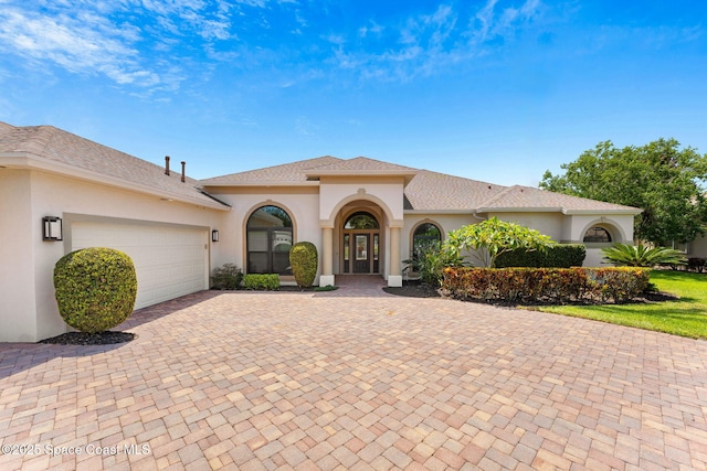 7987 Bradwick Way, Melbourne, FL 32940 - mediterranean / spanish house featuring stucco siding, decorative driveway, and an attached garage