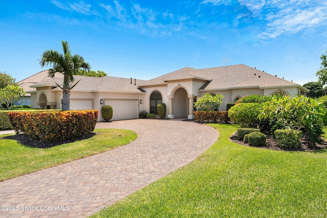 7987 Bradwick Way, Melbourne, FL 32940 - mediterranean / spanish-style house featuring curved driveway, a garage, stucco siding, and a front yard