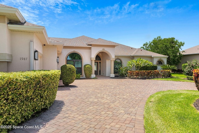 7987 Bradwick Way, Melbourne, FL 32940 - mediterranean / spanish house featuring stucco siding, decorative driveway, and a shingled roof
