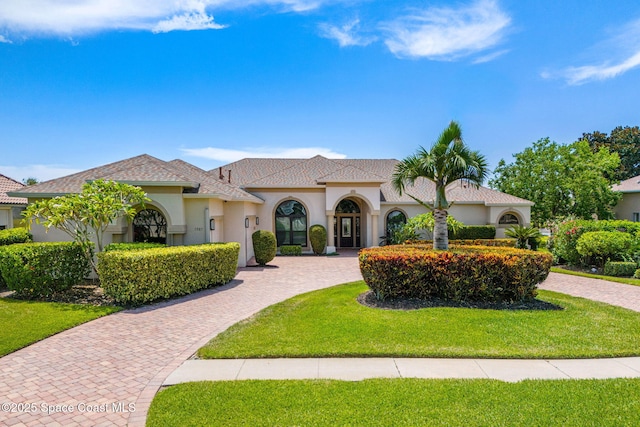 7987 Bradwick Way, Melbourne, FL 32940 - mediterranean / spanish house featuring stucco siding, a front lawn, and curved driveway