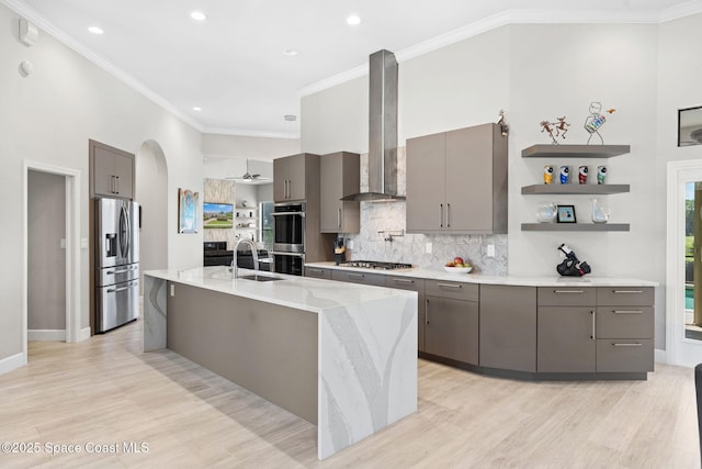 7987 Bradwick Way, Melbourne, FL 32940 - kitchen with appliances with stainless steel finishes, wall chimney exhaust hood, gray cabinetry, light wood finished floors, and ornamental molding