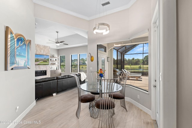 7987 Bradwick Way, Melbourne, FL 32940 - dining space with ceiling fan, crown molding, light wood-style flooring, and a fireplace