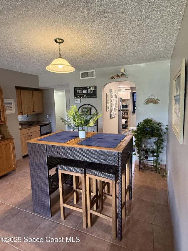 520 Palm Springs Blvd Unit 102, Indian Harbour Beach, FL 32937 - tiled dining space featuring arched walkways and a textured ceiling