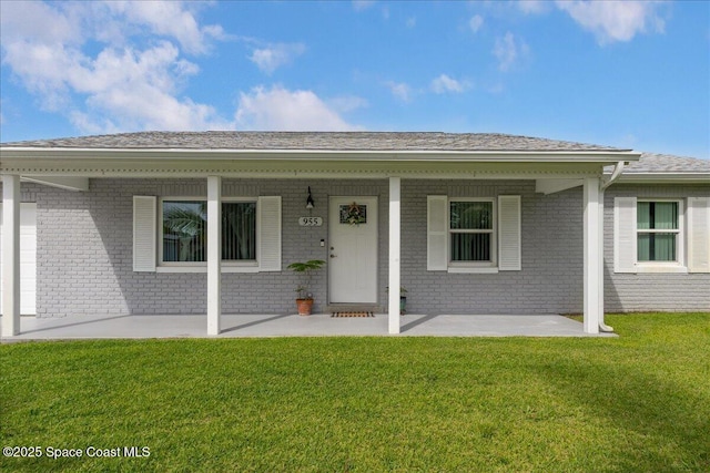 955 Bartlett Ln, Rockledge, FL 32955 - view of front of home with brick siding, a front yard, and roof with shingles