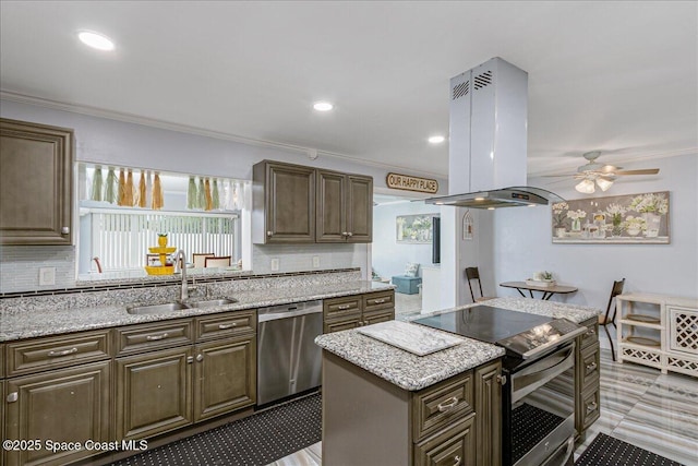 955 Bartlett Ln, Rockledge, FL 32955 - kitchen with appliances with stainless steel finishes, island exhaust hood, a ceiling fan, backsplash, and a center island