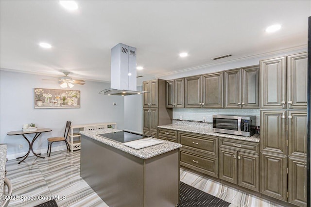 955 Bartlett Ln, Rockledge, FL 32955 - kitchen with island range hood, stainless steel microwave, black electric stovetop, a kitchen island, and a ceiling fan