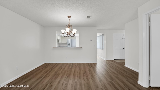 1734 Bluebird Ct, Melbourne, FL 32935 - unfurnished room with a chandelier, wood finished floors, and a textured ceiling