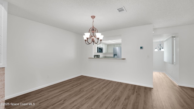 1734 Bluebird Ct, Melbourne, FL 32935 - unfurnished dining area featuring a chandelier, wood finished floors, and a textured ceiling