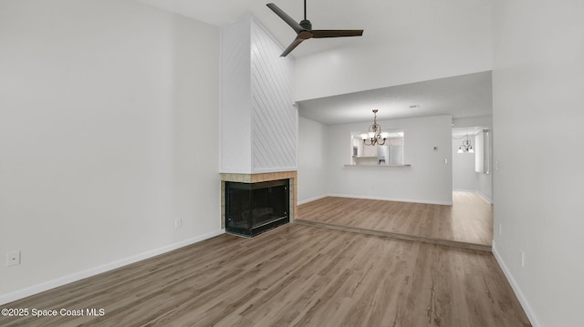 1734 Bluebird Ct, Melbourne, FL 32935 - unfurnished living room featuring a chandelier, wood finished floors, a multi sided fireplace, and a ceiling fan