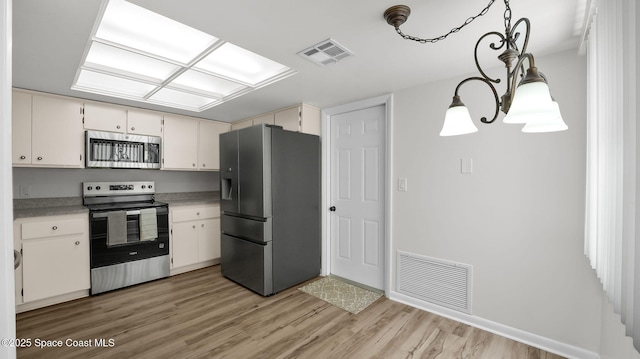 1734 Bluebird Ct, Melbourne, FL 32935 - kitchen with stainless steel appliances, light wood-style floors, light countertops, and white cabinets