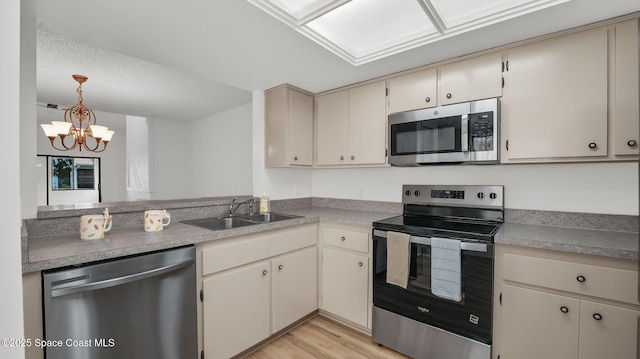1734 Bluebird Ct, Melbourne, FL 32935 - kitchen featuring appliances with stainless steel finishes, cream cabinetry, a chandelier, light wood-type flooring, and pendant lighting