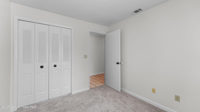1734 Bluebird Ct, Melbourne, FL 32935 - unfurnished bedroom with carpet flooring, a closet, and a textured ceiling