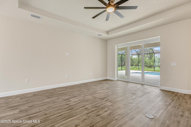 8025 Babcock St SE, Grant-Valkaria, FL 32909 - unfurnished room with a raised ceiling, a ceiling fan, and wood finished floors