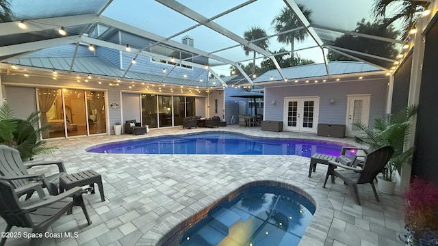 210 Pelican Dr, Melbourne Beach, FL 32951 - outdoor pool featuring french doors, a hot tub, a patio, outdoor lounge area, and glass enclosure