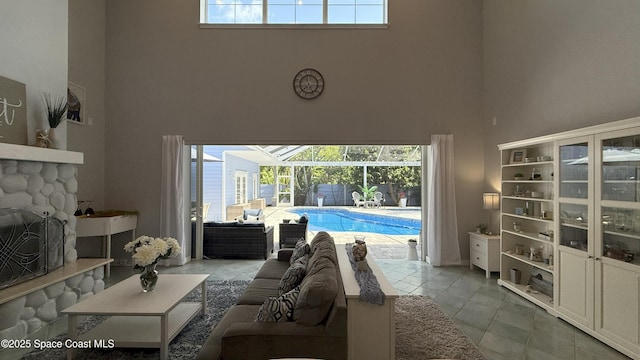 210 Pelican Dr, Melbourne Beach, FL 32951 - tiled living area with a towering ceiling, plenty of natural light, a sunroom, and a fireplace