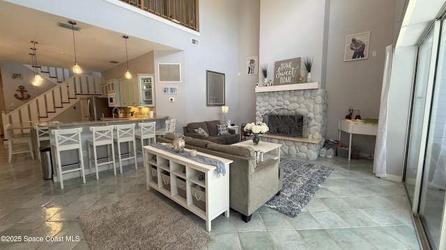 210 Pelican Dr, Melbourne Beach, FL 32951 - living area featuring stairs, a stone fireplace, and a high ceiling