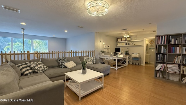 210 Pelican Dr, Melbourne Beach, FL 32951 - living room with wood finished floors, a textured ceiling, and recessed lighting