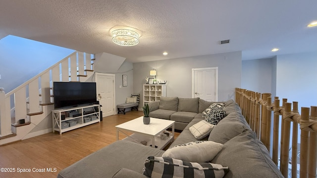 210 Pelican Dr, Melbourne Beach, FL 32951 - living area with stairs, wood finished floors, recessed lighting, and a textured ceiling