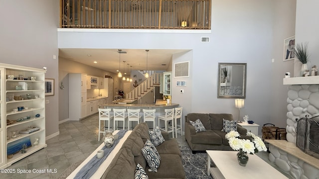 210 Pelican Dr, Melbourne Beach, FL 32951 - living area featuring stairs, a towering ceiling, recessed lighting, and a stone fireplace