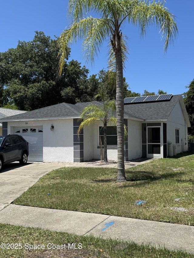 3116 Winchester Dr, Cocoa, FL 32926 - ranch-style home with an attached garage, roof mounted solar panels, a front lawn, driveway, and stucco siding