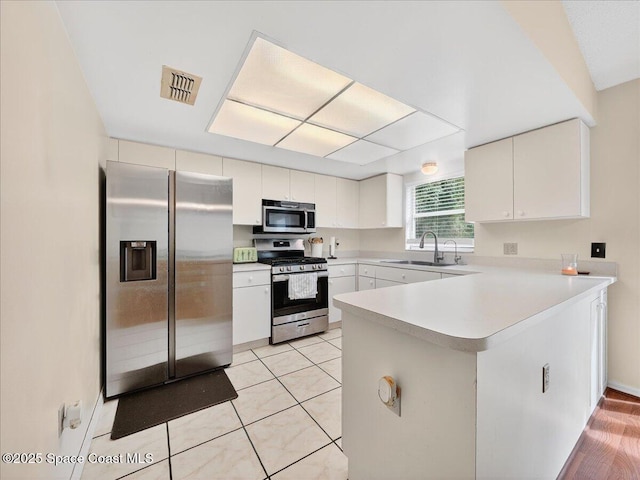 3116 Winchester Dr, Cocoa, FL 32926 - kitchen with appliances with stainless steel finishes, a peninsula, light countertops, and white cabinets