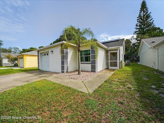 3116 Winchester Dr, Cocoa, FL 32926 - view of front of property with stucco siding, solar panels, a front lawn, a garage, and concrete driveway