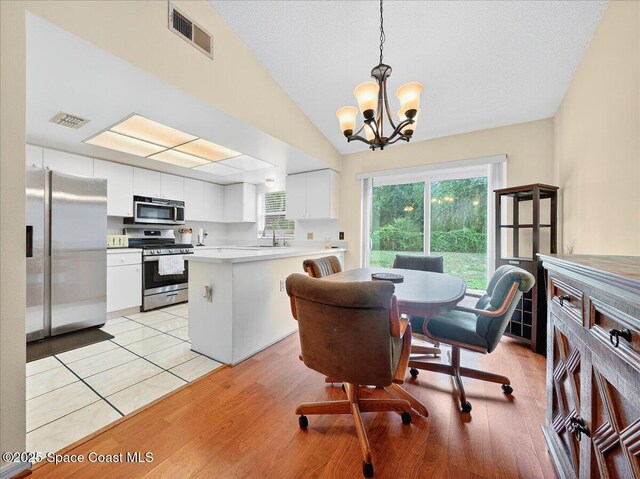 3116 Winchester Dr, Cocoa, FL 32926 - dining area with a chandelier, vaulted ceiling, and light wood-type flooring