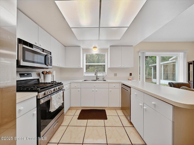 3116 Winchester Dr, Cocoa, FL 32926 - kitchen with stainless steel appliances, a peninsula, light countertops, and white cabinetry