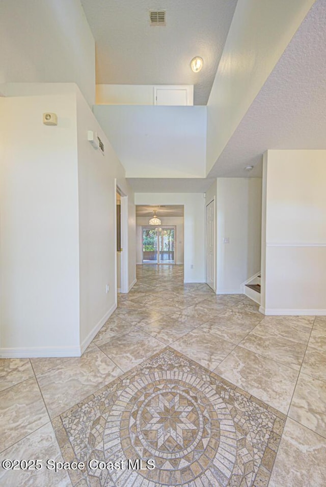 6065 Balboa St, Cocoa, FL 32927 - unfurnished room featuring a textured ceiling, light marble finish flooring, and a towering ceiling