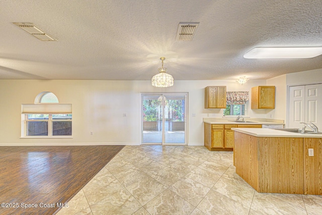 6065 Balboa St, Cocoa, FL 32927 - kitchen featuring light countertops, a chandelier, a textured ceiling, open floor plan, and pendant lighting
