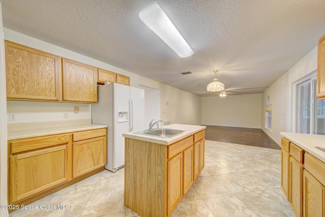 6065 Balboa St, Cocoa, FL 32927 - kitchen featuring white fridge with ice dispenser, a textured ceiling, a center island with sink, light countertops, and open floor plan