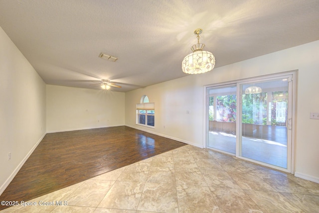 6065 Balboa St, Cocoa, FL 32927 - unfurnished room with a chandelier, ceiling fan, wood finished floors, and a textured ceiling