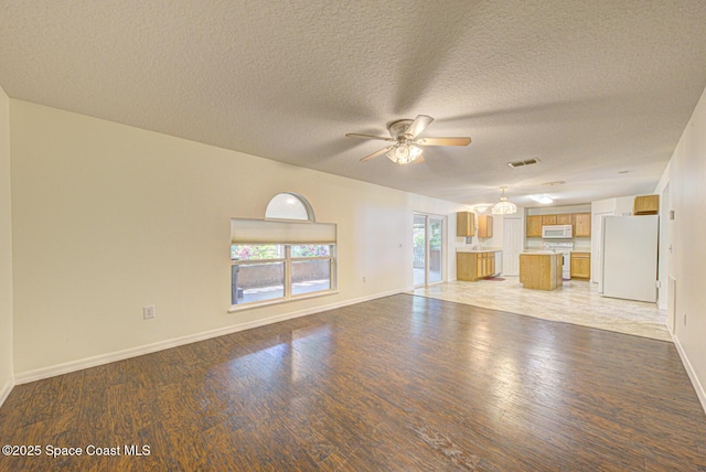 6065 Balboa St, Cocoa, FL 32927 - unfurnished living room featuring a ceiling fan, light wood-style floors, and a textured ceiling