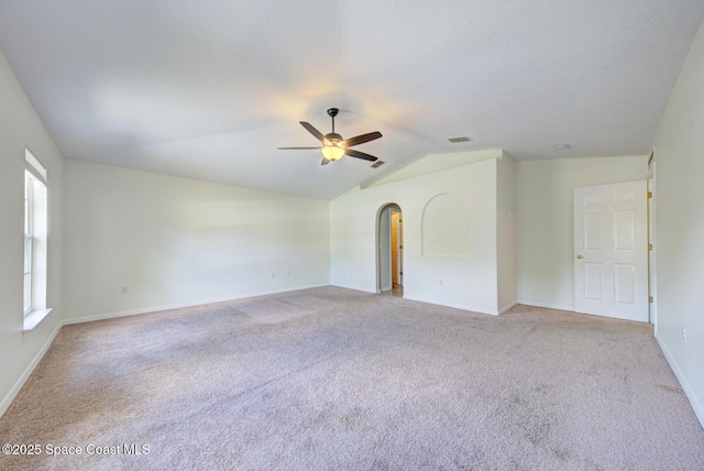 6065 Balboa St, Cocoa, FL 32927 - unfurnished room featuring ceiling fan, light carpet, vaulted ceiling, and arched walkways