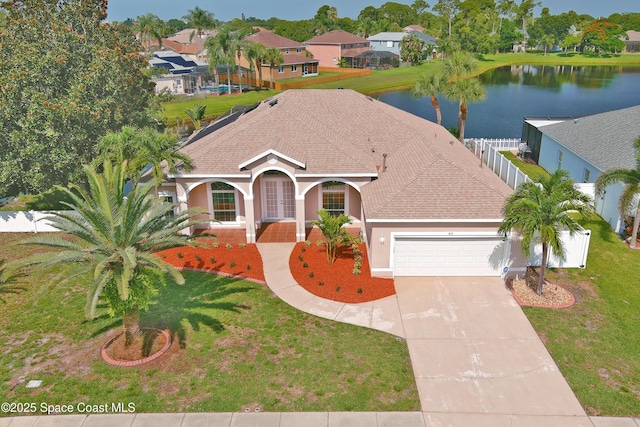 401 Stonehenge Cir, Rockledge, FL 32955 - mediterranean / spanish house featuring a garage, stucco siding, driveway, roof with shingles, and a water view