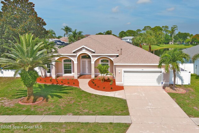 401 Stonehenge Cir, Rockledge, FL 32955 - mediterranean / spanish home with an attached garage, concrete driveway, stucco siding, and a shingled roof