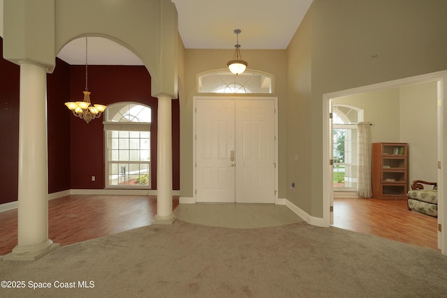 401 Stonehenge Cir, Rockledge, FL 32955 - entrance foyer with carpet, a chandelier, decorative columns, a high ceiling, and arched walkways