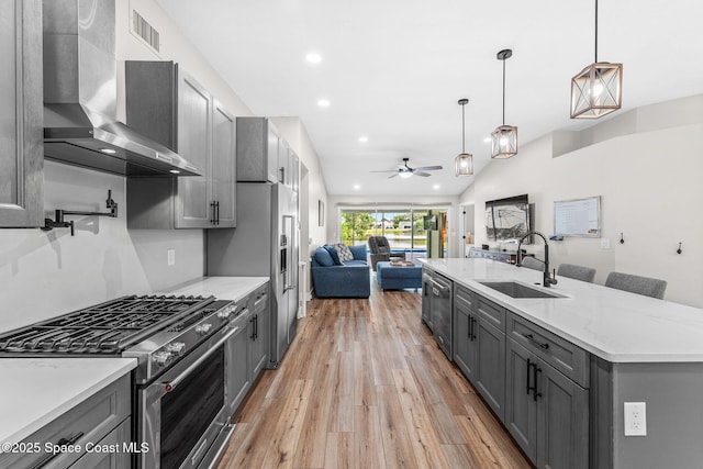 1218 Rolling Meadows Dr, Rockledge, FL 32955 - kitchen featuring stainless steel appliances, wall chimney range hood, gray cabinets, open floor plan, and a ceiling fan