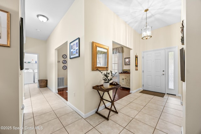 4595 Alan Shepard Ave, Cocoa, FL 32926 - entryway featuring separate washer and dryer, light tile patterned floors, and a chandelier