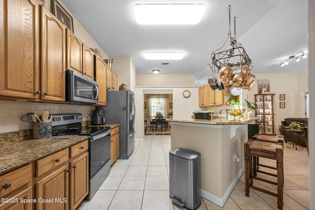 4595 Alan Shepard Ave, Cocoa, FL 32926 - kitchen featuring appliances with stainless steel finishes, a kitchen bar, backsplash, and light tile patterned floors