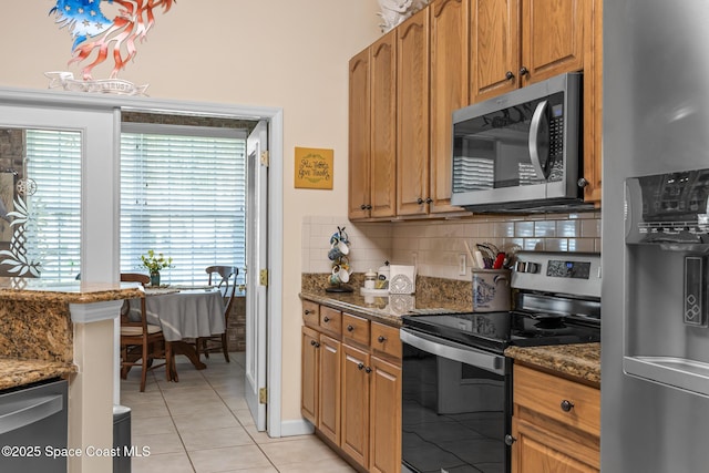 4595 Alan Shepard Ave, Cocoa, FL 32926 - kitchen with stainless steel appliances, tasteful backsplash, dark stone countertops, and light tile patterned floors