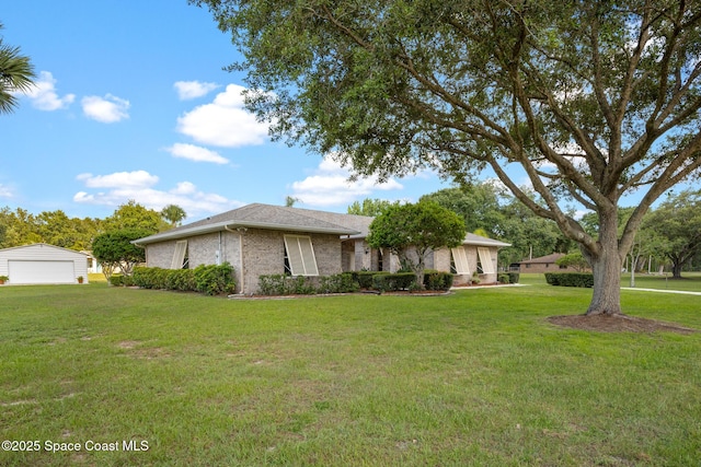 4595 Alan Shepard Ave, Cocoa, FL 32926 - view of front of property featuring a detached garage, a front lawn, an outbuilding, and brick siding