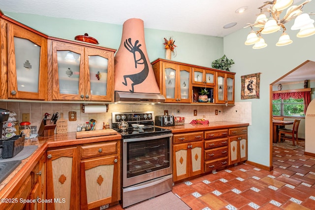 3717 SW Bayfield St, Cocoa, FL 32926 - kitchen featuring stainless steel range with electric cooktop, under cabinet range hood, a chandelier, backsplash, and brown cabinetry