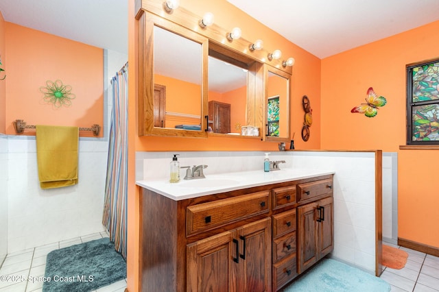 3717 SW Bayfield St, Cocoa, FL 32926 - bathroom with tile walls, tile patterned floors, double vanity, and wainscoting