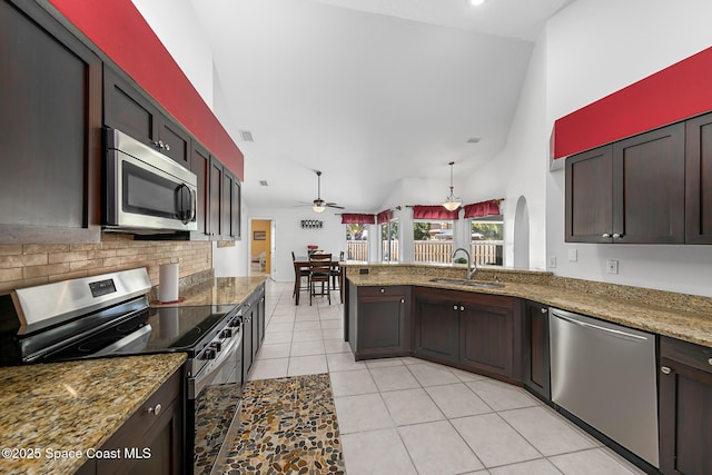 100 Matthews St, Satellite Beach, FL 32937 - kitchen featuring stainless steel appliances, light tile patterned floors, a ceiling fan, backsplash, and high vaulted ceiling